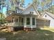 Quaint home featuring an airy wraparound porch and a connecting screened in porch at 100 Parliament Ct, Fayetteville, GA 30215