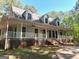 Inviting two-story home with a charming, expansive porch and craftsman style dormers at 100 Parliament Ct, Fayetteville, GA 30215