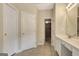 This bathroom features tiled floors, a dual sink vanity, a large mirror, and a doorway into a walk-in closet at 1619 Cascade Overlook, Peachtree City, GA 30269