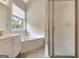 This bathroom features a soaking tub under a sunny window, plus a glass-enclosed shower and vanity at 1619 Cascade Overlook, Peachtree City, GA 30269