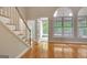 Bright living room featuring hardwood floors, large windows, and staircase at 1619 Cascade Overlook, Peachtree City, GA 30269