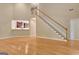 Open-concept living room features hardwood floors, staircase, and a view into kitchen at 1619 Cascade Overlook, Peachtree City, GA 30269