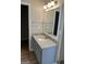 Bathroom vanity with granite countertop, mirror, and modern fixtures, adjacent to a walk-in closet at 12214 Cypress Way, Fayetteville, GA 30215
