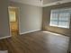 Bright bedroom featuring wood flooring, a large window with blinds, and an ensuite bathroom at 12214 Cypress Way, Fayetteville, GA 30215