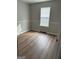 Bright bedroom featuring hardwood floors and a large window at 12214 Cypress Way, Fayetteville, GA 30215