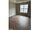 Empty bedroom with wood floors, neutral walls, and a large window at 12214 Cypress Way, Fayetteville, GA 30215