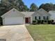 Single-Gathering home with two-car garage, neutral siding, and landscaped lawn at 12214 Cypress Way, Fayetteville, GA 30215