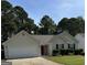 Inviting single-Gathering home with a two-car garage, a red door, and manicured front yard at 12214 Cypress Way, Fayetteville, GA 30215