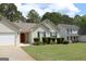 Traditional single Gathering home showcasing a red front door and manicured landscaping at 12214 Cypress Way, Fayetteville, GA 30215