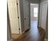 Hallway with multiple doors leading to bedrooms and bathrooms, featuring modern wood flooring at 12214 Cypress Way, Fayetteville, GA 30215