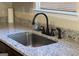 Granite countertop with a stainless steel sink and modern faucet at 12214 Cypress Way, Fayetteville, GA 30215