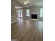 Open living room with wood floors, fireplace, and access to outdoor deck at 12214 Cypress Way, Fayetteville, GA 30215