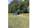 Community playground with a slide and swings, surrounded by green grass and mature trees at 12214 Cypress Way, Fayetteville, GA 30215