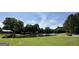 Scenic pond with picnic tables, lush greenery, and shade trees, perfect for outdoor gatherings at 12214 Cypress Way, Fayetteville, GA 30215