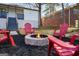 Backyard with a fire pit surrounded by red Adirondack chairs on black mulch at 1766 Ware Ave, East Point, GA 30344