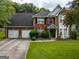 Traditional two-story brick home featuring a two-car garage and manicured front lawn at 345 S Magnolia Se Walk, Atlanta, GA 30349