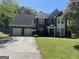 Charming two-story brick home featuring an attached two-car garage and mature landscaping in a suburban setting at 345 S Magnolia Se Walk, Atlanta, GA 30349