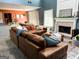 Cozy living room featuring a brick fireplace, comfortable brown sectional, and views to the kitchen area at 345 S Magnolia Se Walk, Atlanta, GA 30349