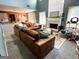 Cozy living room featuring a brick fireplace, comfortable brown sectional, and views to the kitchen area at 345 S Magnolia Se Walk, Atlanta, GA 30349