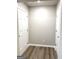 Hallway with fresh paint, laminate flooring, base trim and multiple doors at 1605 Hydrangea Ln, Mcdonough, GA 30253