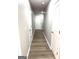 Hallway featuring laminate floors and neutral paint leading to a white entry door at 1605 Hydrangea Ln, Mcdonough, GA 30253