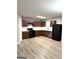 Kitchen featuring stainless steel appliances, dark cabinets, modern laminate flooring, and white backsplash at 1605 Hydrangea Ln, Mcdonough, GA 30253