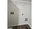 A laundry room offers connections, wood-look flooring, and a storage shelf at 1605 Hydrangea Ln, Mcdonough, GA 30253