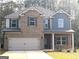 Charming two-story home with brick facade, well-manicured lawn, and attached two-car garage at 305 Wheeler Creek Ln # 21, Mcdonough, GA 30252