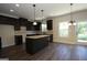 Spacious kitchen features dark cabinets, an island with granite countertop, and stainless steel appliances at 305 Wheeler Creek Ln # 21, Mcdonough, GA 30252