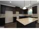 Modern kitchen boasts dark wood cabinetry, an island with granite countertops, and stainless steel appliances at 305 Wheeler Creek Ln # 21, Mcdonough, GA 30252