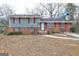 Charming split-level home with brick and siding exterior, complemented by red shutters and a well-kept lawn at 77 Crystal River Dr, Riverdale, GA 30274