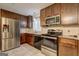 Well-equipped kitchen with stainless steel appliances, dark wood cabinets, and granite countertops at 77 Crystal River Dr, Riverdale, GA 30274