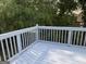 White painted wooden deck with lush green trees in the background offers a relaxing outdoor space at 111 Hamilton Rd, Peachtree City, GA 30269