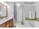 Neutral bathroom featuring a wood vanity, white tile flooring, and a combination tub and shower at 5260 Sherwood Way, Cumming, GA 30040