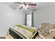 Cozy bedroom features a ceiling fan, natural light from the window, and a comfortable seating area at 5260 Sherwood Way, Cumming, GA 30040