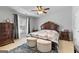 Elegant bedroom with dark wood furniture, plush upholstered ottomans, ceiling fan, and a Parisian-themed bedspread at 5260 Sherwood Way, Cumming, GA 30040