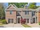 Charming townhome with a brick and gray exterior, a well-manicured lawn, and a two-car garage at 5260 Sherwood Way, Cumming, GA 30040