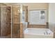 Bathroom featuring a glass enclosed shower, separate tub and natural light from a window at 2638 Lake Manor Cir, Duluth, GA 30096