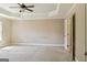 Spacious carpeted bedroom with a tray ceiling, natural light, and a closet entrance at 2638 Lake Manor Cir, Duluth, GA 30096
