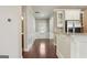 Hallway featuring dark hardwood floors, white wainscoting, and views of kitchen and outdoor access at 2638 Lake Manor Cir, Duluth, GA 30096