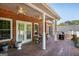 Covered back porch with white columns, ceiling fans, and outdoor seating, perfect for relaxation and entertaining at 1108 Sequoia Trl, Mcdonough, GA 30252