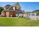 Spacious backyard featuring a brick and stucco home with a deck, white fencing, and lush green grass at 1108 Sequoia Trl, Mcdonough, GA 30252