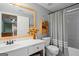 Well-lit bathroom includes gray walls, flower decor, and a decorative mirror and shower curtain at 1108 Sequoia Trl, Mcdonough, GA 30252