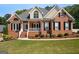 Charming brick home featuring a covered front porch, manicured landscaping, and black shutters at 1108 Sequoia Trl, Mcdonough, GA 30252