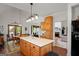Open kitchen island with pendant lighting, wood cabinetry and view to living spaces at 1108 Sequoia Trl, Mcdonough, GA 30252