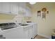 Efficient laundry room featuring ample cabinets, sink, and updated appliances for convenience at 1108 Sequoia Trl, Mcdonough, GA 30252