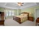 Tranquil main bedroom with a tray ceiling, ceiling fan, and a large window providing ample natural light at 1108 Sequoia Trl, Mcdonough, GA 30252