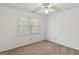 Bedroom with neutral walls, carpet, and window bringing in natural light and ceiling fan at 9276 Fieldstone Ct, Jonesboro, GA 30236