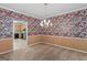 Spacious dining room with floral wallpaper, chandelier, and open access to the kitchen for easy entertaining at 9276 Fieldstone Ct, Jonesboro, GA 30236
