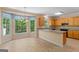 Cozy eat-in kitchen boasting granite counters, natural wood cabinetry and large windows with wooded views at 9276 Fieldstone Ct, Jonesboro, GA 30236